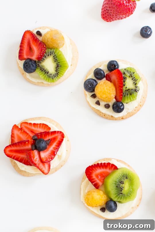 A perfectly arranged Fruit Pizza Cookie with blueberries, strawberries, and kiwi, garnished with mint.