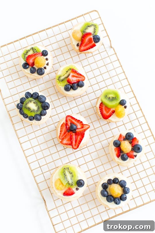 Assortment of mini desserts and appetizers, including fruit pizza cookies, ideal for entertaining
