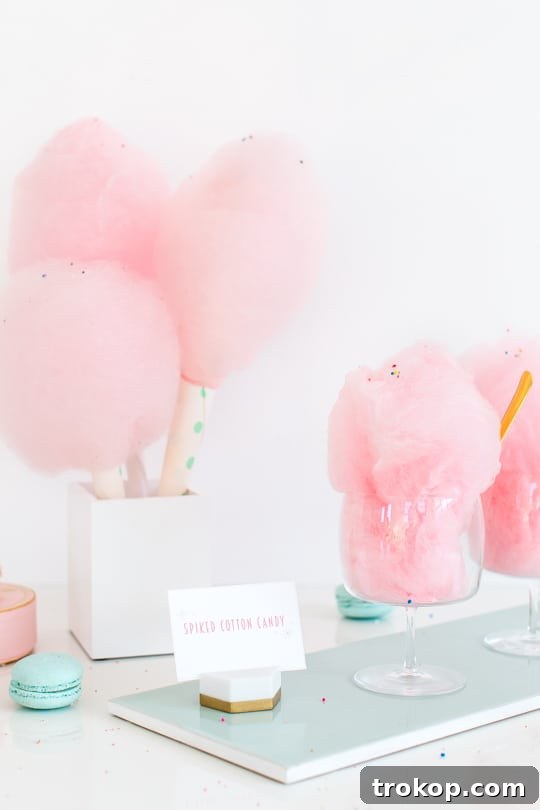 Hand holding a fresh cone of pink spiked cotton candy