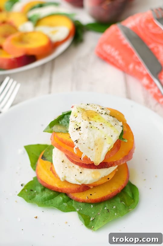Caprese's Peachy Summer Twist 3 Close-up of a beautifully arranged Peach Caprese Salad on a white plate