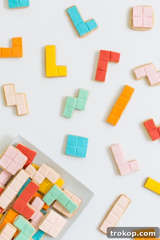 Pixel Perfect Tetris Bites 4 Hands arranging brightly colored fondant shapes on baked Tetris cookies