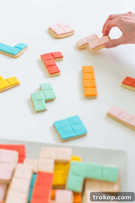 Pixel Perfect Tetris Bites 9 Assorted Tetris cookies with colorful fondant designs arranged on a baking sheet