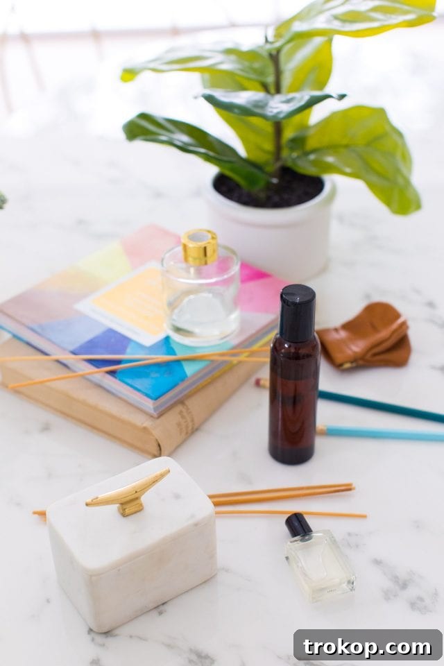 Handcrafted Home Fragrance 4 Various supplies laid out neatly for making a DIY reed diffuser, including a bottle, carrier oil, essential oils, and rattan reeds.