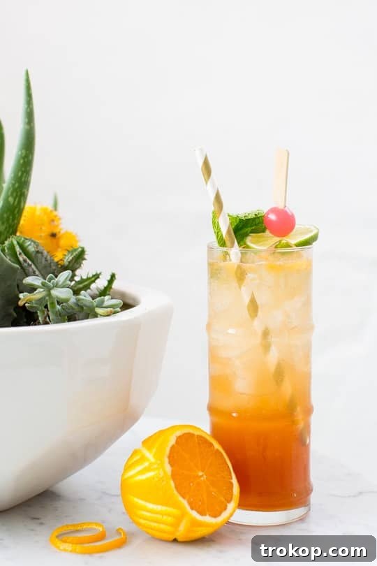Refreshing Esmeralda Fizz cocktail with a carved orange peel garnish, perfect for summer.