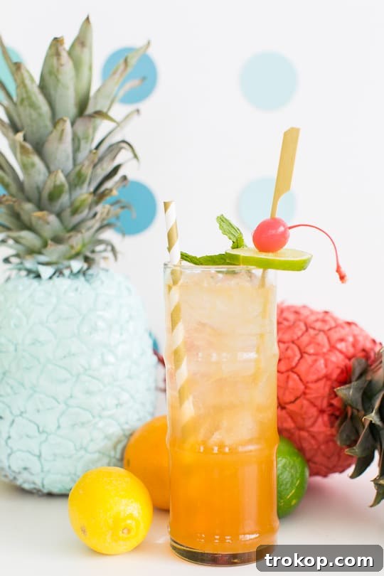 Esmeralda Fizz cocktail in a tall glass, garnished with a spectacular carved orange peel.