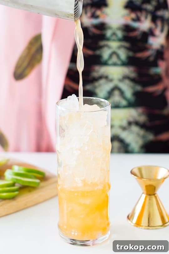 Ingredients for Esmeralda Fizz Cocktail laid out, including rum, brandy, and citrus fruits.
