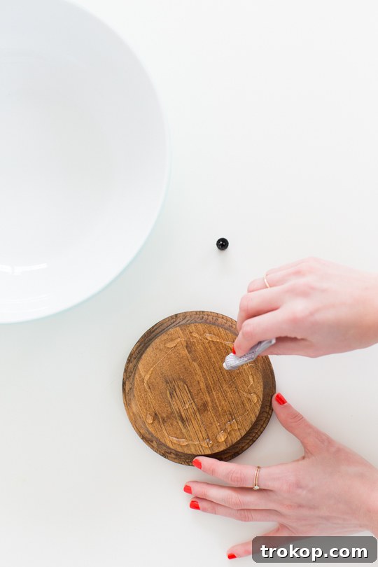 Close-up of the DIY Footed Serving Bowl creation process, showing the bowl being glued to the wooden base.