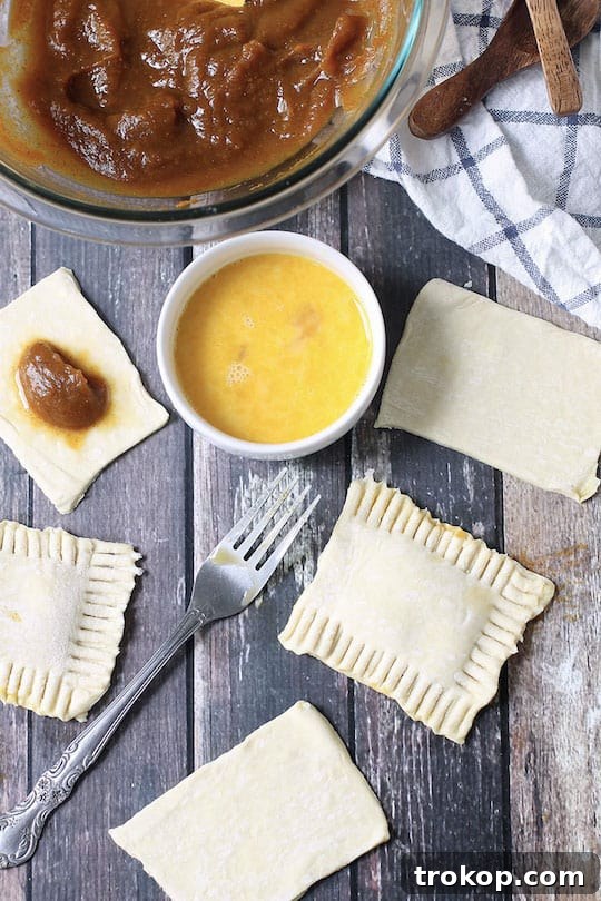 DIY Pumpkin Spice Toaster Pastries 5 Freshly baked homemade pumpkin pop tarts cooling on a rack.