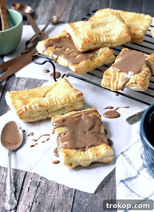 DIY Pumpkin Spice Toaster Pastries 7 Pumpkin Pie Pop Tarts on a rustic wooden surface with fall decorations.