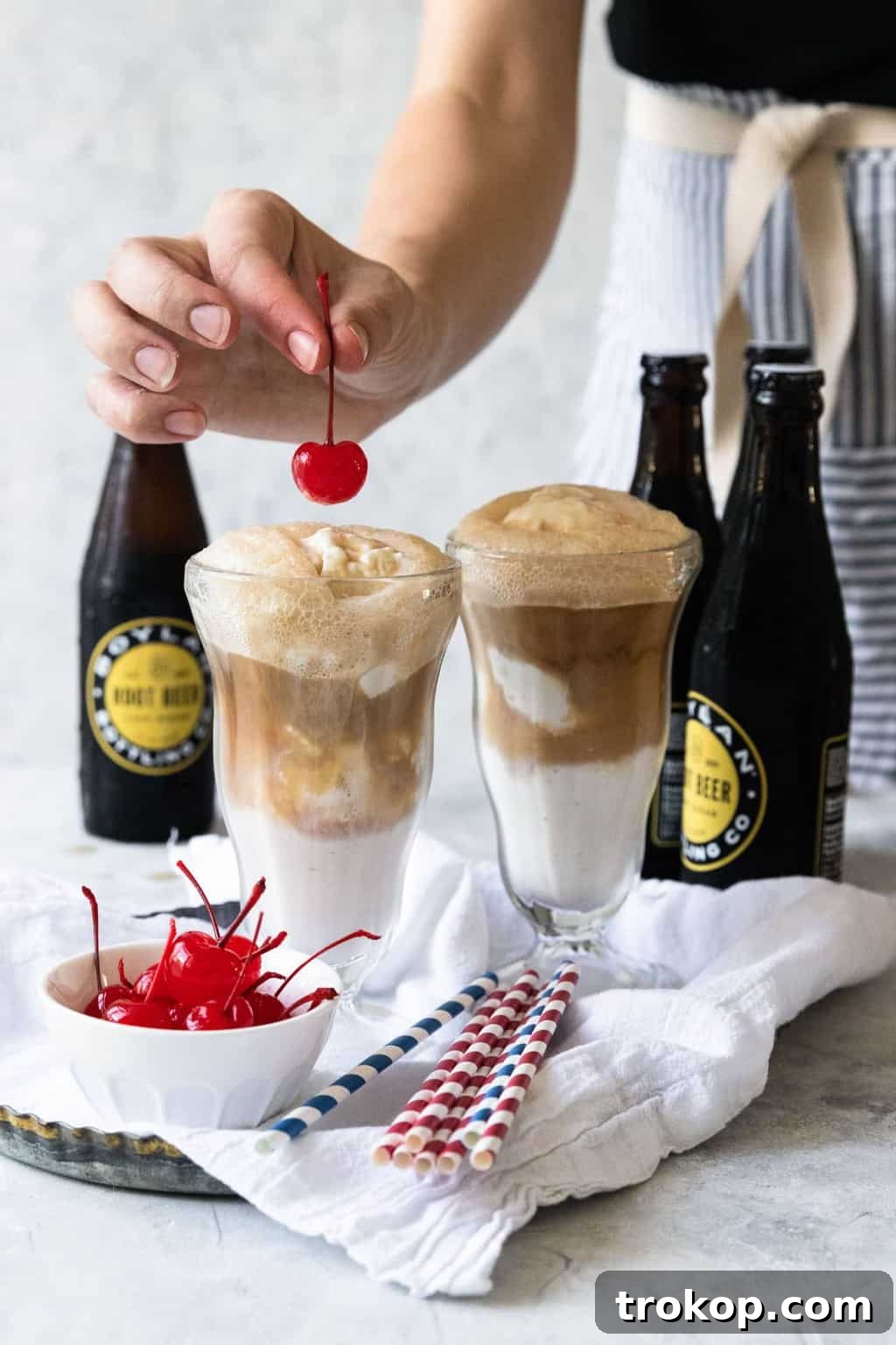 Close-up of a root beer float topped with a vibrant maraschino cherry, ready to be enjoyed.