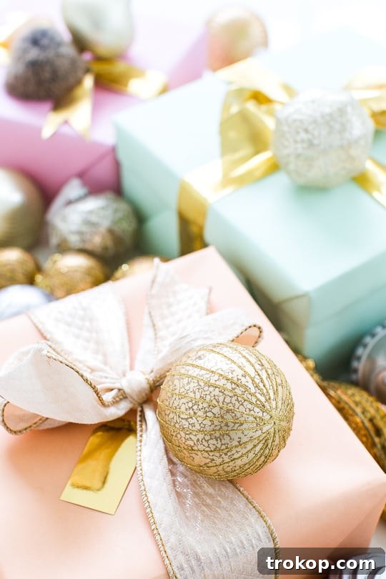 Martha Stewart's Holiday Crafting: Signature Tree Toppers & DIY Ornaments 8 Customized pink and gold Martha Stewart ornaments hanging on a snowy Christmas tree