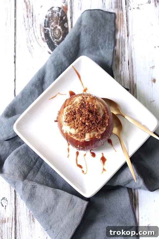 Decadent Cheesecake Stuffed Apples 7 Two cheesecake stuffed baked apples on a plate, garnished with caramel