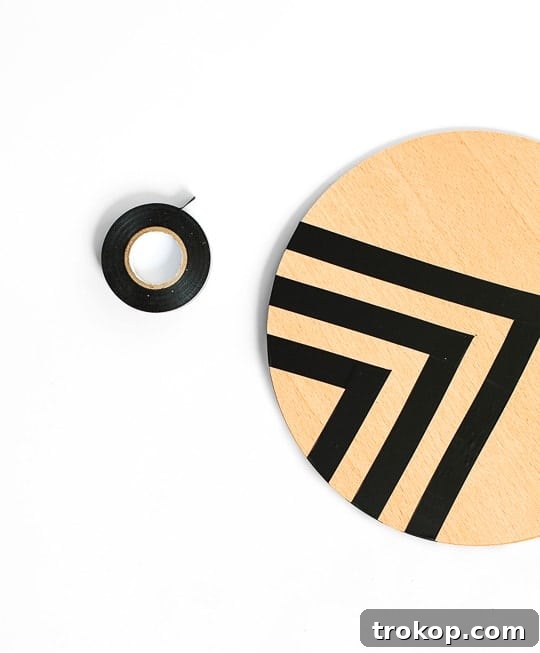 Applying tape to create a patterned design on the side table