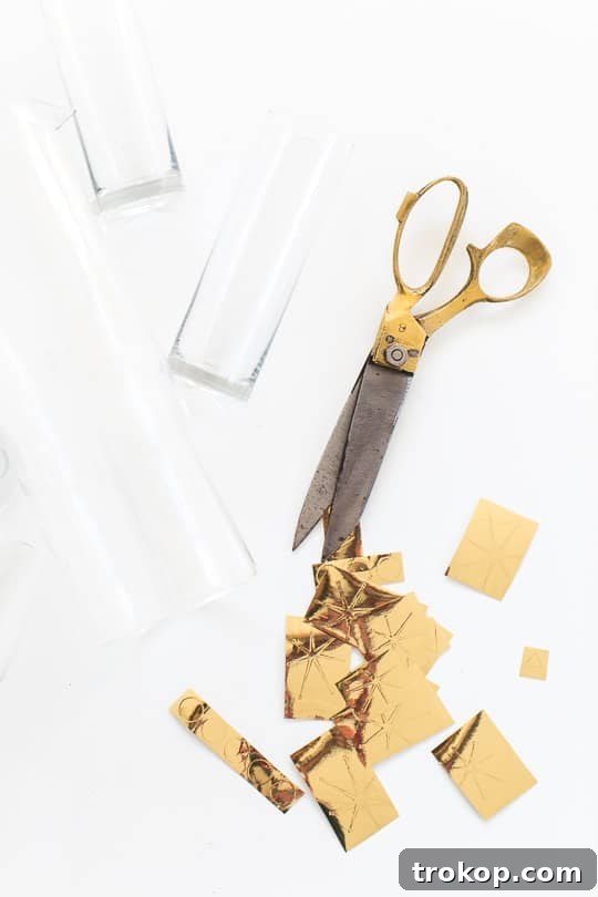 Applying gold vinyl patterns to a glass, showing the peel-and-stick process.