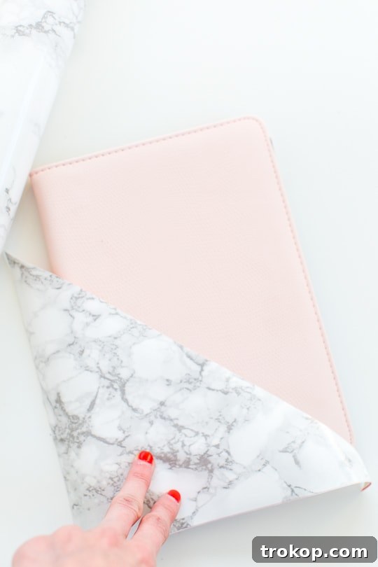 DIY Tablet and E-Reader Cosies 6 A selection of materials for the DIY Kindle cover, including a folding folio notepad and a roll of marble adhesive paper