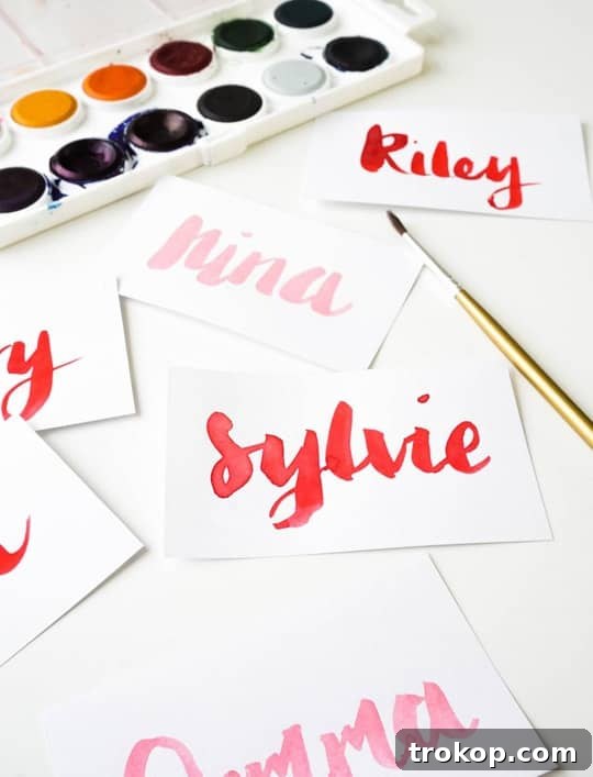Handmade Watercolor Ribbon Candy Place Settings 5 Close-up of hand-lettered names on place cards.