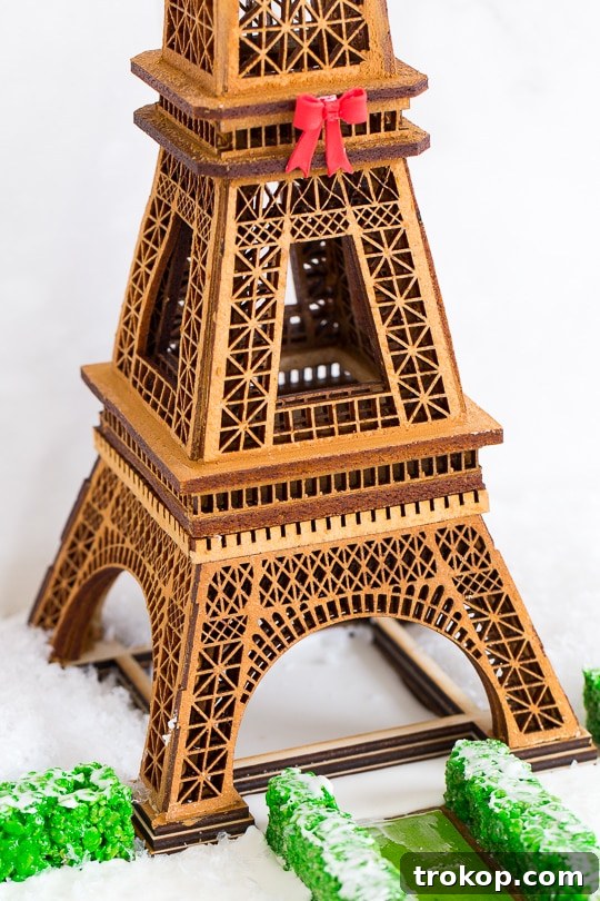 Gingerbread Eiffel Tower standing majestically, adorned with festive icing