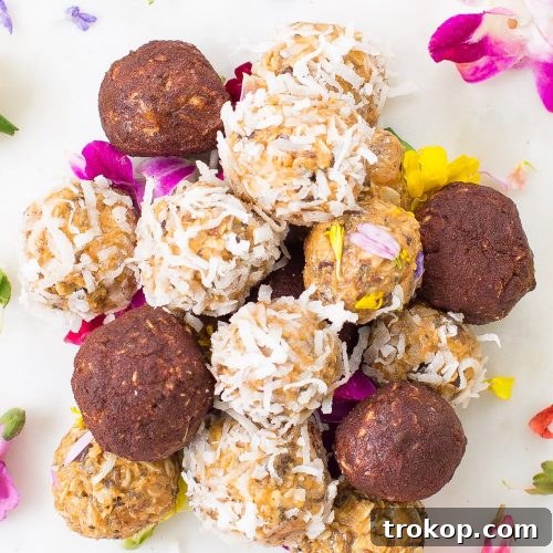 A mound of peanut butter balls with coconut flakes, cinnamon, and edible flowers