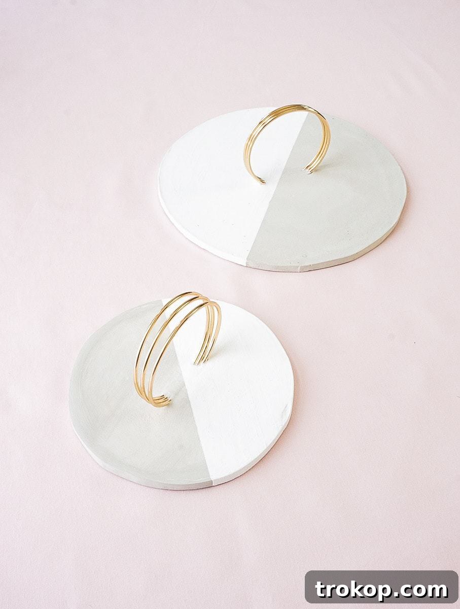 Finished DIY concrete tray with a painted diagonal design and brass handles, ready for use
