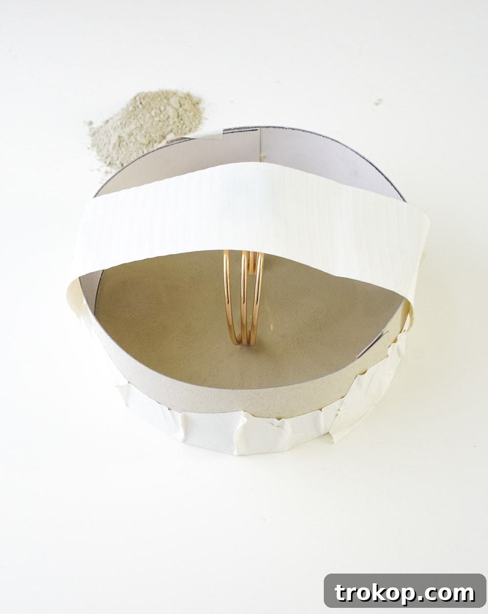 Taping two gold rings together to form the handles for the concrete tray