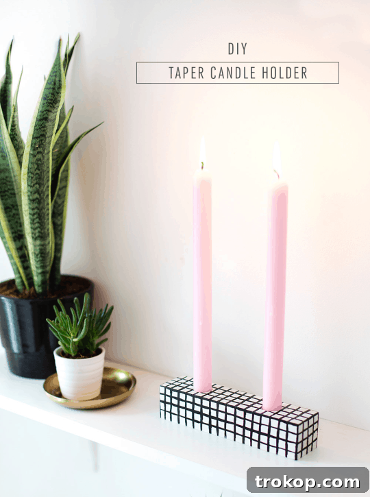 Handmade Patterned Candle Decor 10 A beautifully patterned DIY candle holder with two lit pink candles, surrounded by green foliage, making for an attractive and festive home decor piece.
