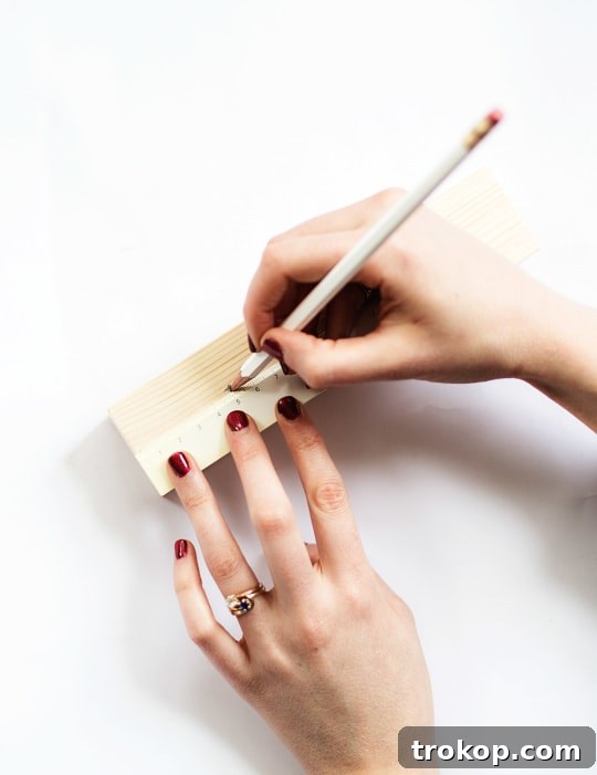 Handmade Patterned Candle Decor 6 A ruler and pencil used to measure and mark precise points on a wooden block, illustrating the crucial preparation step for crafting DIY wooden candle holders.