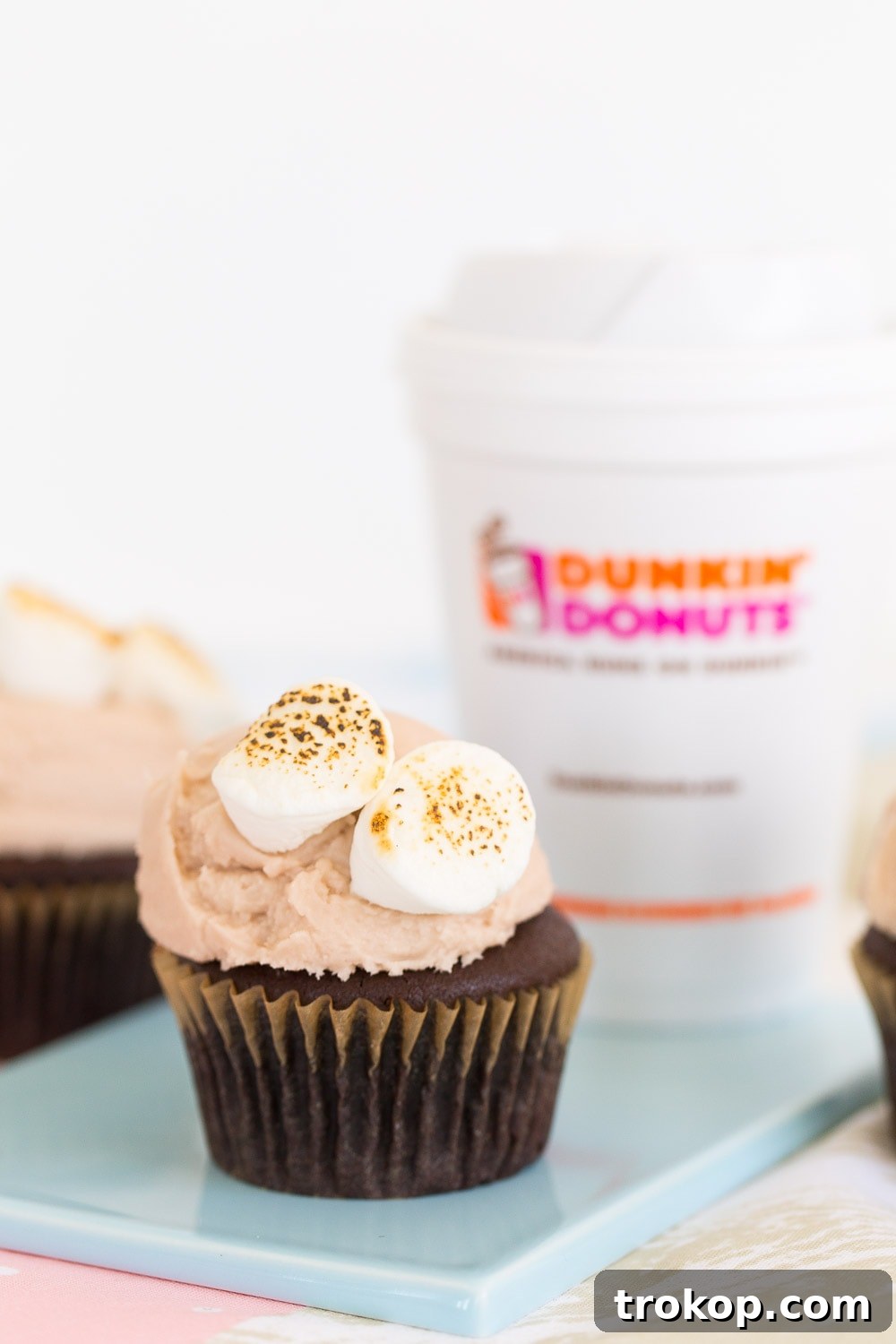 Side view of two Dunkin' Donuts hot chocolate cupcakes, highlighting the height of the frosting and marshmallows.