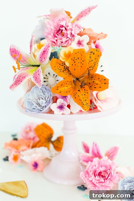 A beautifully decorated sugar flower cake resting on an elegant cake stand.