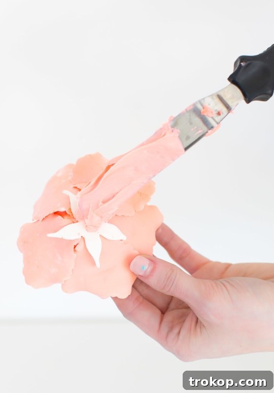 A DIY sugar flower cake adorned with various spring-themed edible decorations.