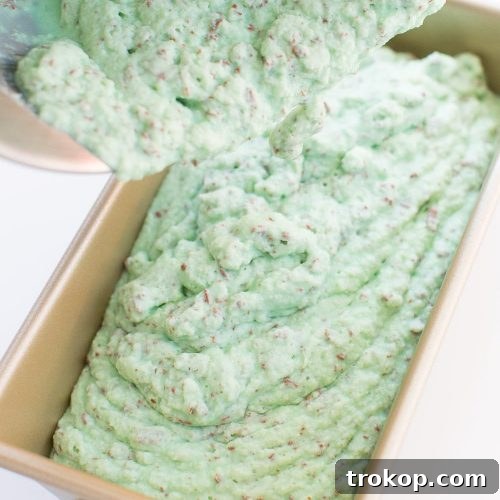 Crème de Menthe Ice Cream, showcasing a swirl of green mint and white creamy texture with chocolate chips throughout.