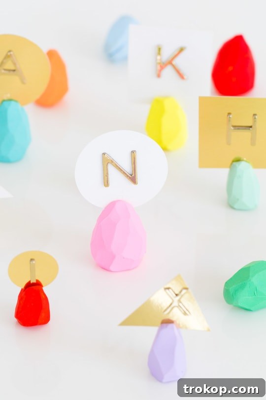 A selection of DIY faceted Easter egg place card holders in various pastel colors.