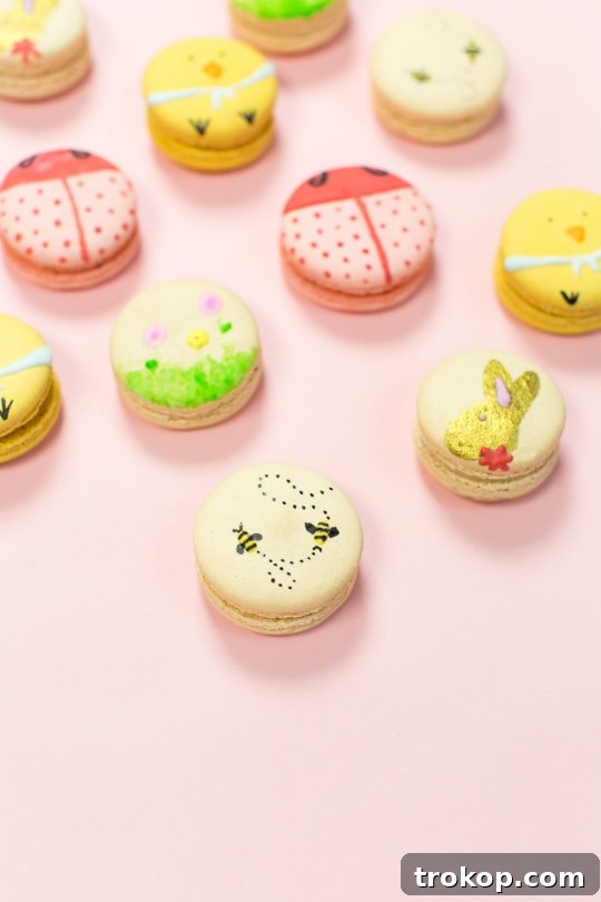 Various pastel-colored macarons decorated with detailed Easter motifs