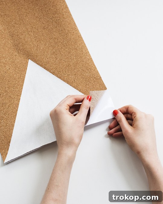 Craft Your Custom Desk Organizer 9 Applying painter's tape and masking paper to the cork board to create a crisp geometric design with white spray paint.