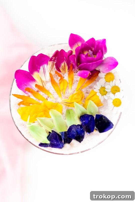 Pink Gin Sour Perfection with Handmade Grenadine 3 Close-up of a colorful cocktail with edible flowers