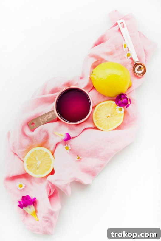 Pink Gin Sour Perfection with Handmade Grenadine 4 Lemon and measuring cup beside cocktail ingredients