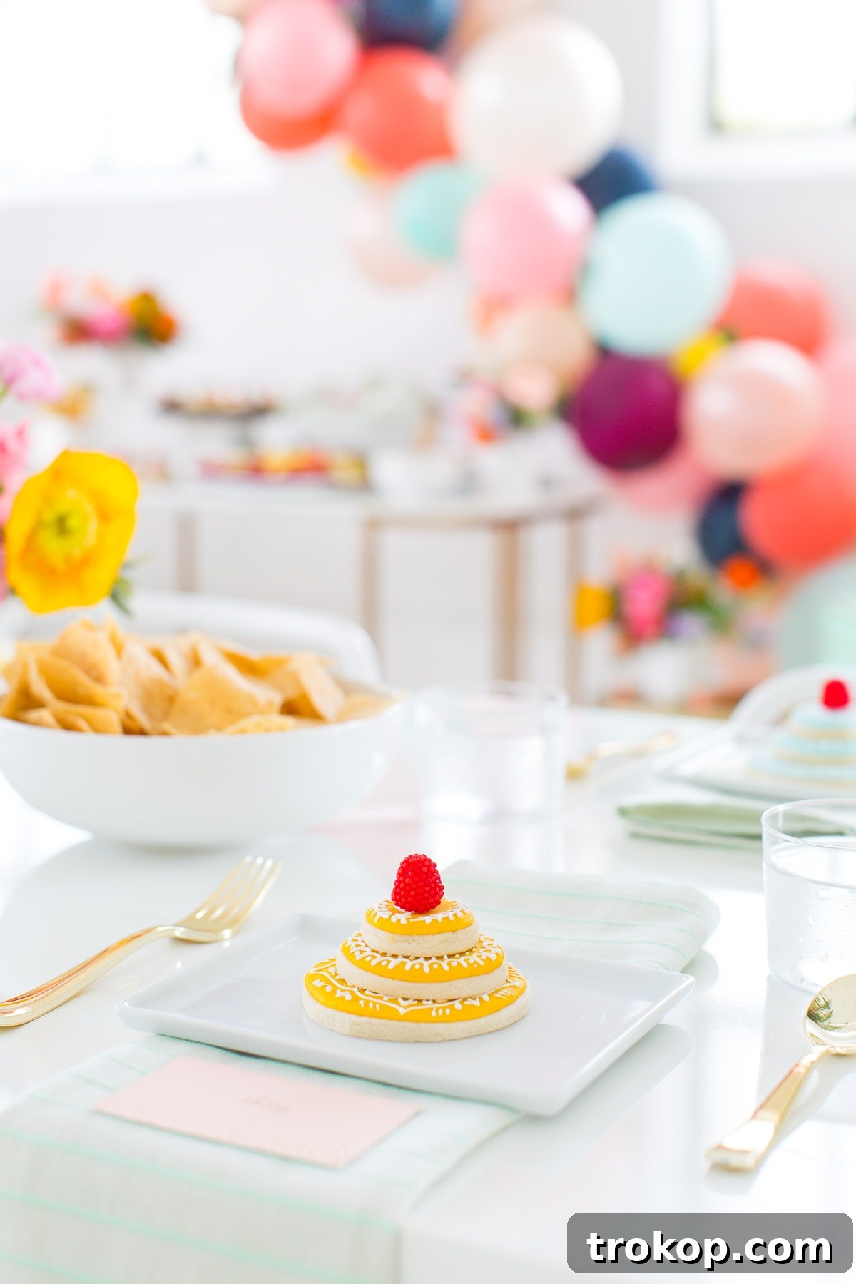Spring Bliss Our Bridal Shower 12 Floral centerpiece and place setting with metallic gold utensils at a bright bridal shower.