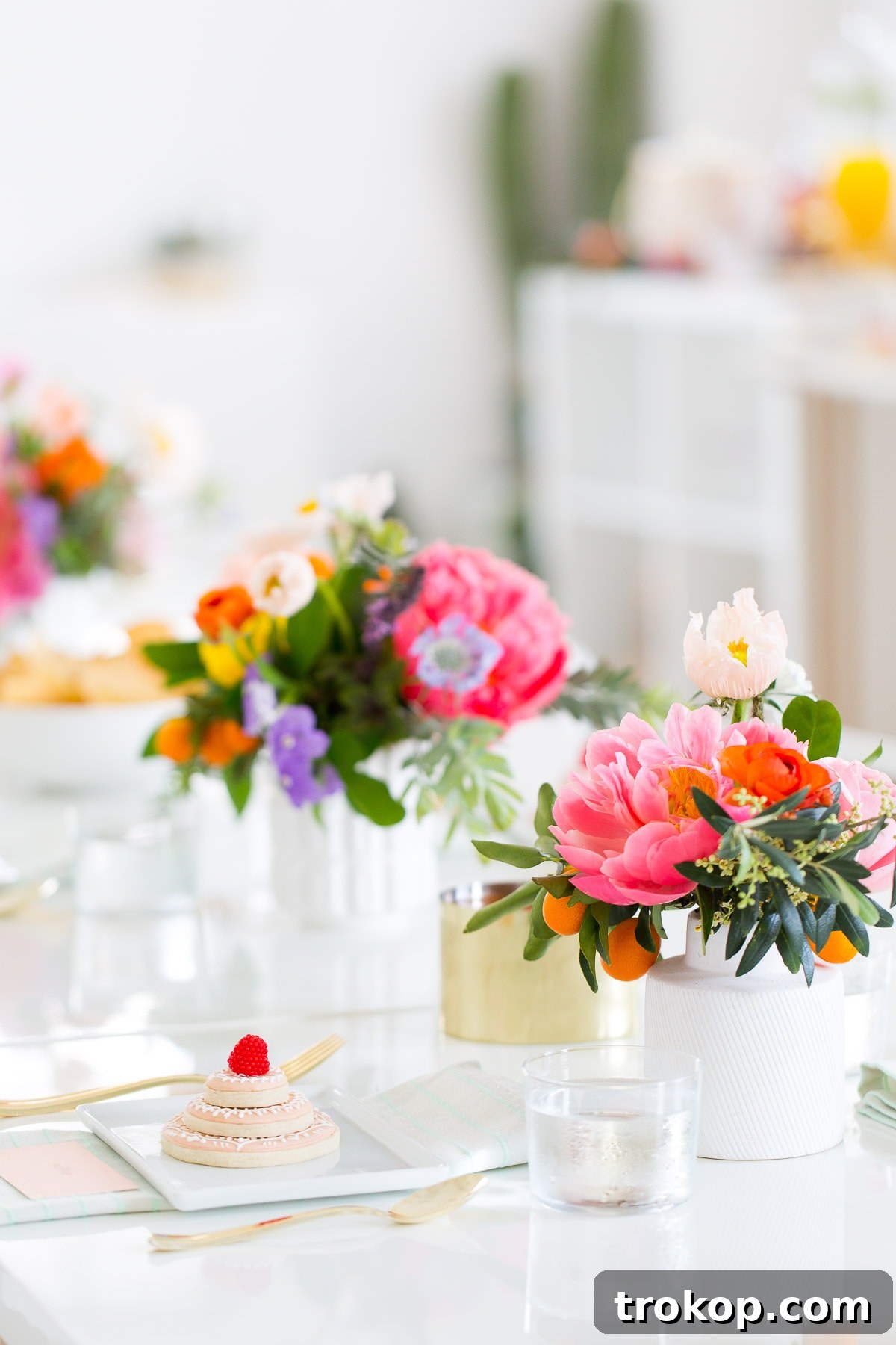 A stunning floral balloon arch serving as a backdrop for a bridal shower buffet table.