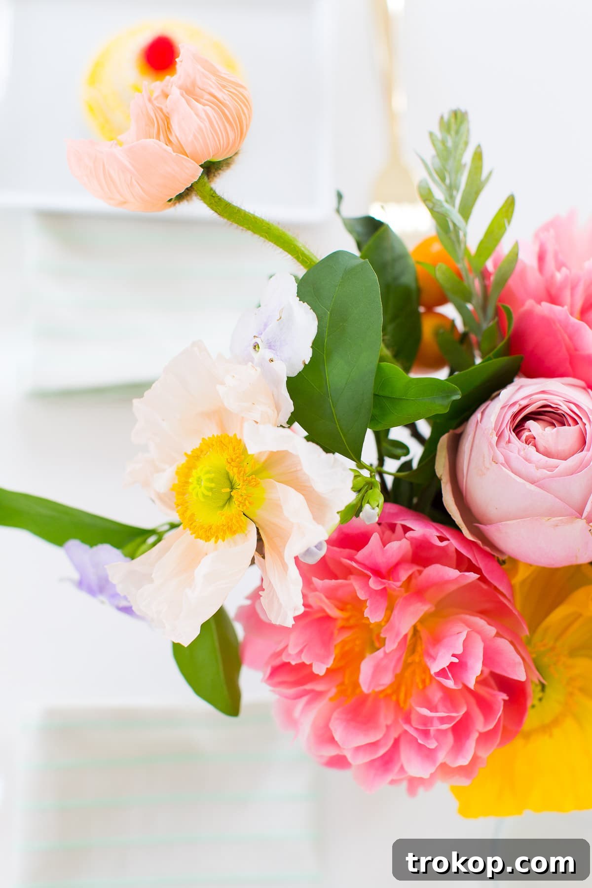 Chic bar cart decorated with flowers and a variety of beverages for a bridal shower.
