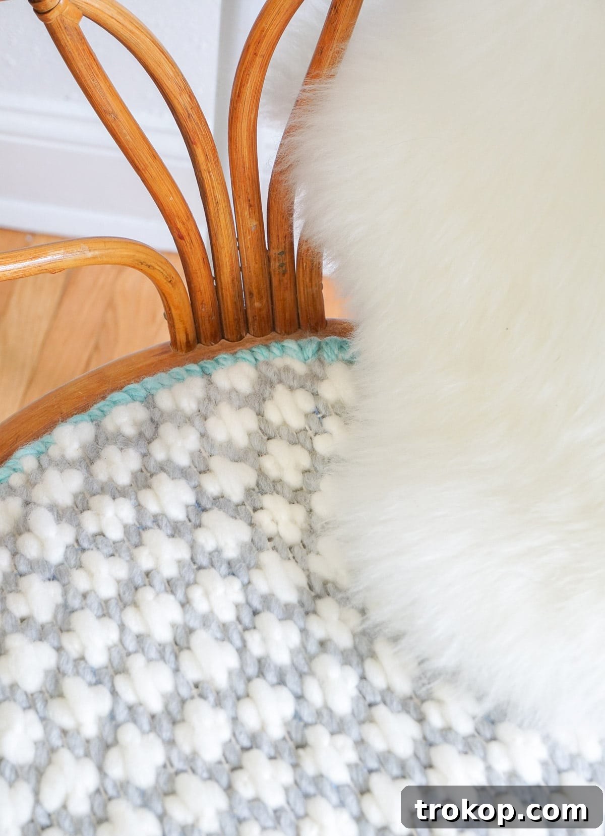Artisan Oversized Cross-Stitch Pillow 12 A beautifully handcrafted oversized cross-stitched cushion resting on a stylish mid-century chair, adding comfort and a unique textural element to the space.