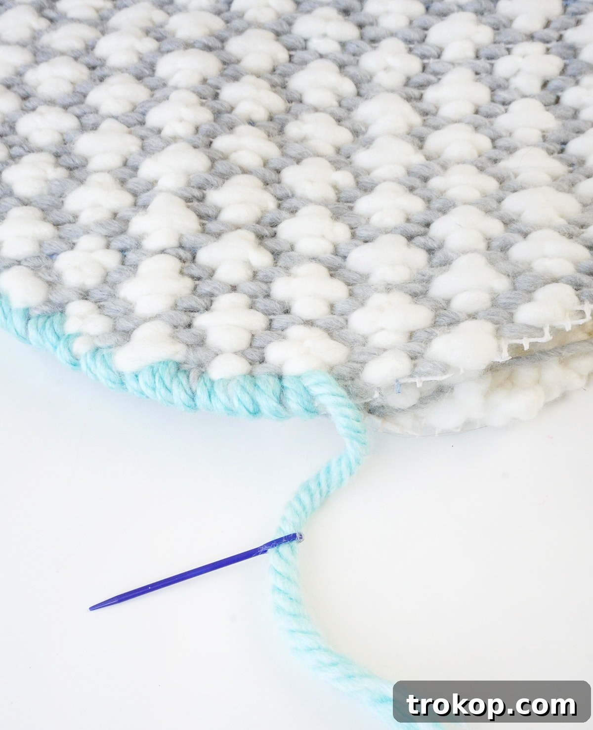 Artisan Oversized Cross-Stitch Pillow 9 Layers of synthetic fiber batting cut into a circular shape, prepared to be placed between the two cross-stitched panels.