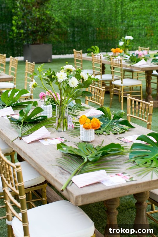 Attendees engaged in making their floral swags, surrounded by tropical arrangements