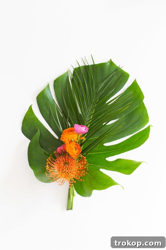 Close-up of tropical flowers and greenery on a bar cart swag
