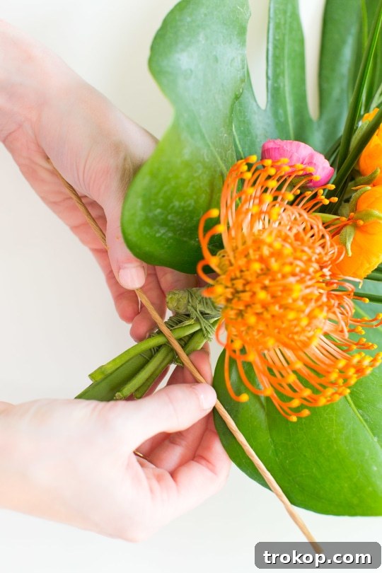 Continuing to add layers of vibrant pincushion protea flowers to the DIY swag