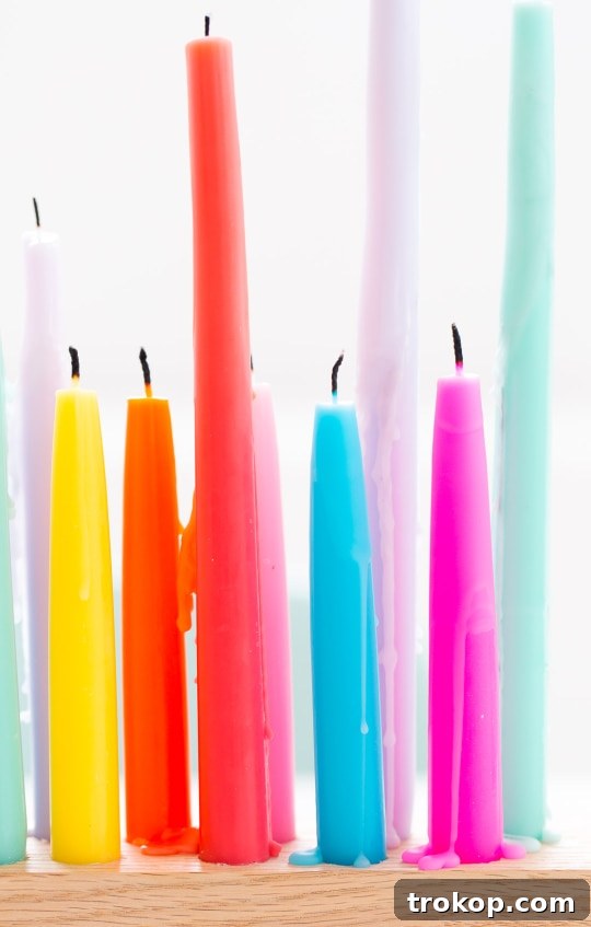 A beautifully arranged rainbow taper candle holder on a wooden surface, ready for entertaining