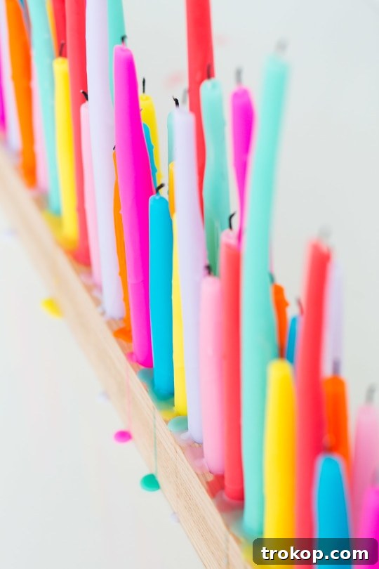 A DIY taper candle holder with colorful candles, showcasing the finished product with a subtle drip effect