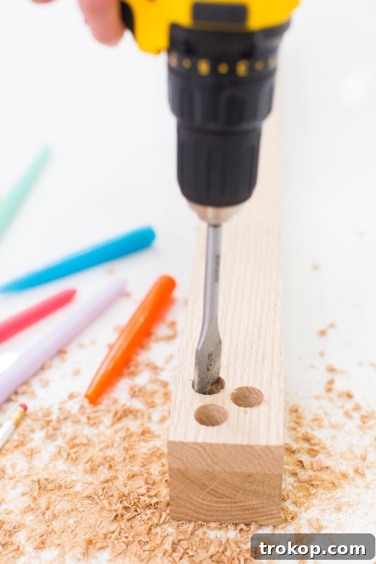 Detail shot of drilling a hole into a wooden board for a DIY taper candle holder