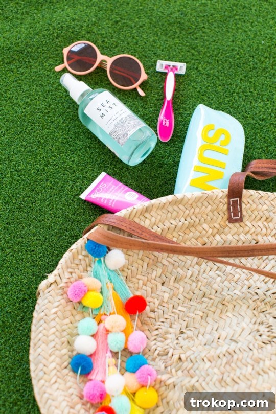 Stylishly posed DIY pom pom tassel beach bag, ready for a sunny day out.