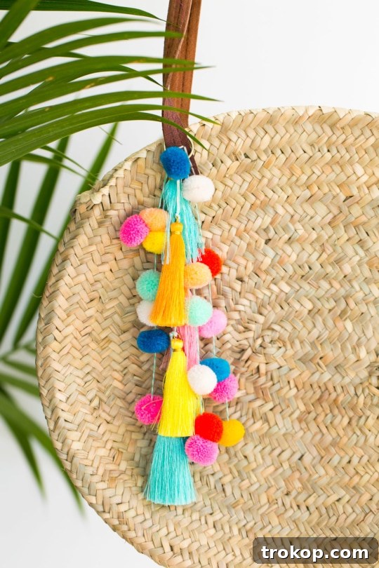 Close-up of crafting materials including colorful pom poms, tassels, twine, and a woven bag, ready for the DIY project.