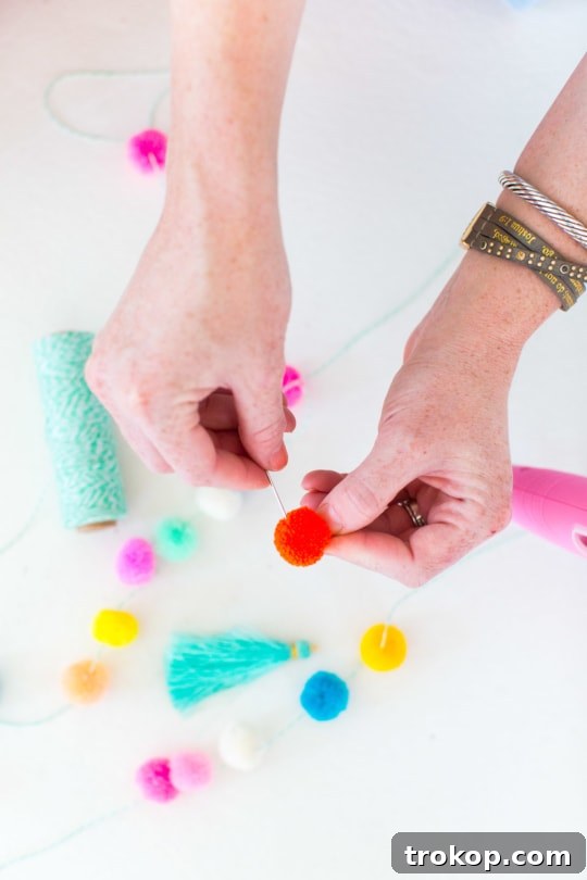 Planning the layout of pom poms and tassels on a circular woven bag to visualize the final DIY design.