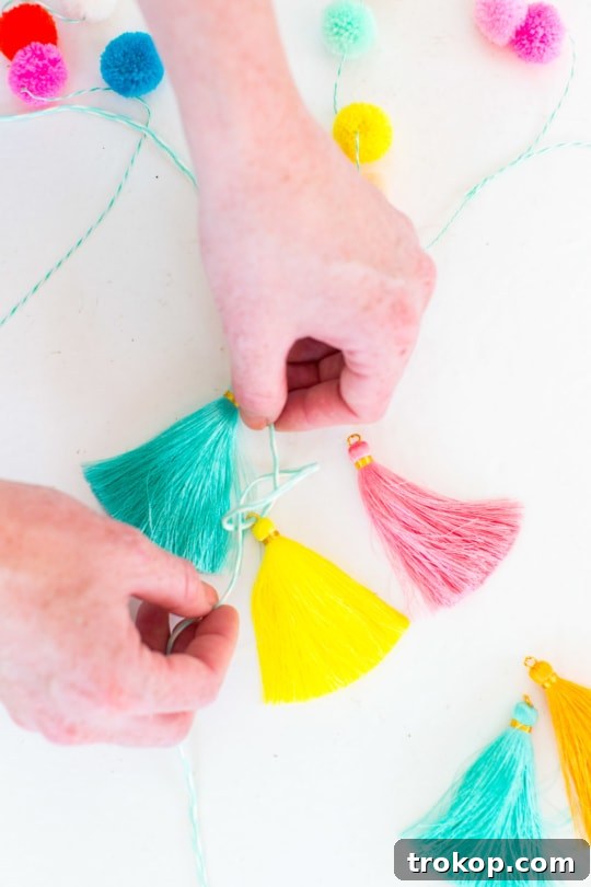 Attaching vibrant tassels onto a cording trim, ensuring they slightly overlap for a full, rich look.